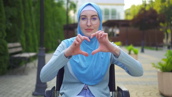 Portrait Smiling Young Muslim Woman Disabled in Traditional Scarf Sitting in a Wheelchair in the