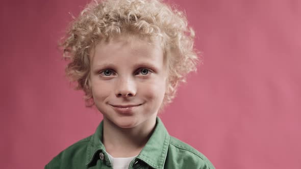 Little Blonde Boy Wearing Big Headphones and Nodding His Head