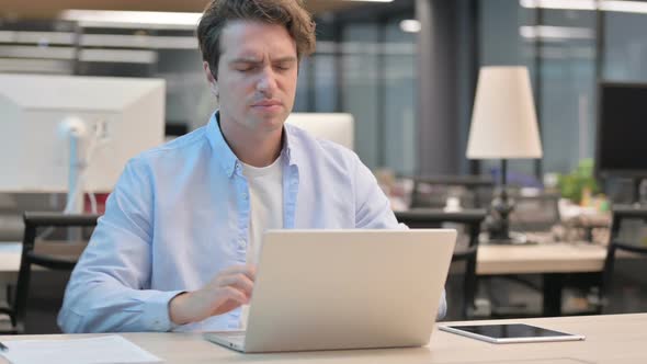 Man Having Back Pain While Using Laptop in Office