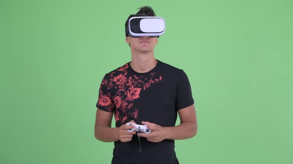 Happy Young Handsome Man Playing Games and Using Virtual Reality Headset