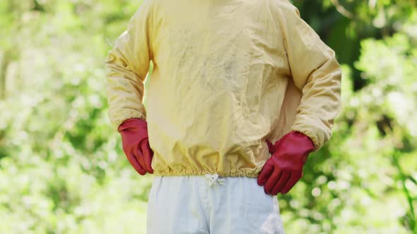 Portrait of smiling caucasian male beekeeper in protective clothing