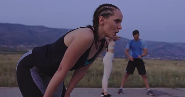 Multiethnic Group of Athlete Resting After Running in Night Time on a Panoramic Road