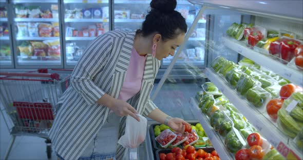 Pretty Woman Buys Food Fruits Apples Oranges in the Market in the Supermarket