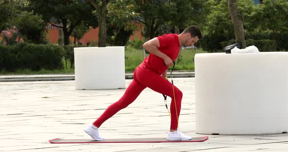 Young fitness man does exercise with elastic band.