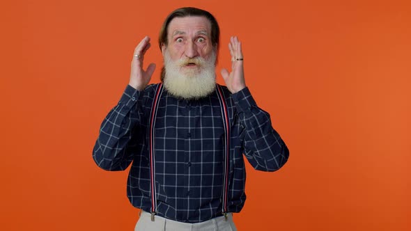 Excited Amazed Elderly Man Raising Hands in Surprise Looking at Camera Shocked By Sudden Victory