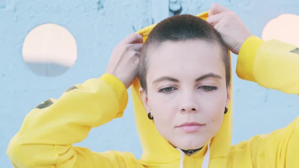 Portrait of Young Woman with Shaved Hair in Street Urban Background