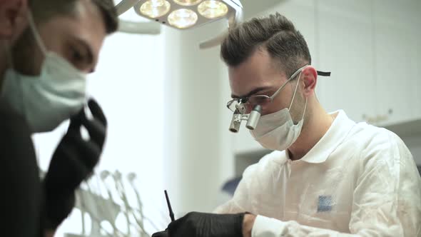 doctor, surrounded by assistants, performs an operation