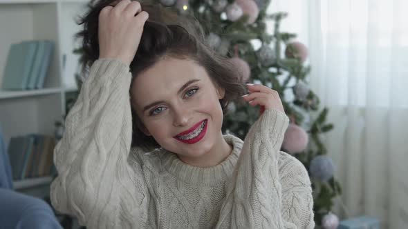 Portrait of Beautiful Woman in Cozy Home with Christmas Tree Smiling To Camera