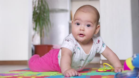 Portrait of a Nice Newborn Baby  Lying on His Stomach Looking Interestingly at Camera