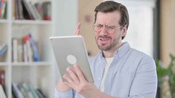 Portrait of Man in Glasses Reacting to Loss on Tablet