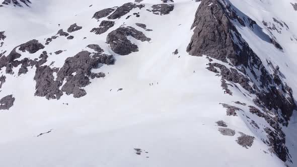 Anonymous travelers walking on Picos de Europa mountains covered with snow alt