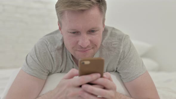 Close Up of Man Using Smart Phone in Bed