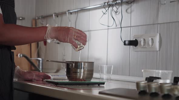 Chef Pouring a Glass of Water in the Pot in the Kitchen