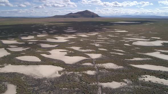 Flying over desert landscape in Utah towards volcanic butte