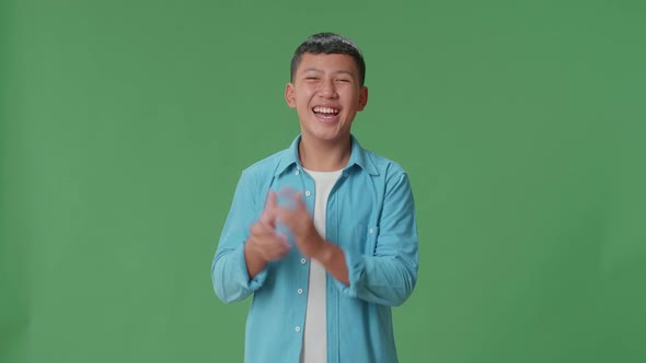 Young Asian Boy Clapping Her Hands In The Green Screen Studio