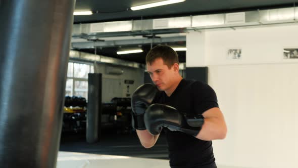 MMA Fighter Boxers Doing Some Training on a Punching Bag at a Gym Close Up Power Punch Kicks Macro