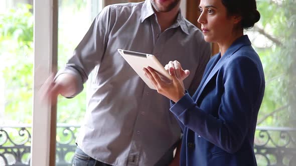 Couple touring new home with digital tablet