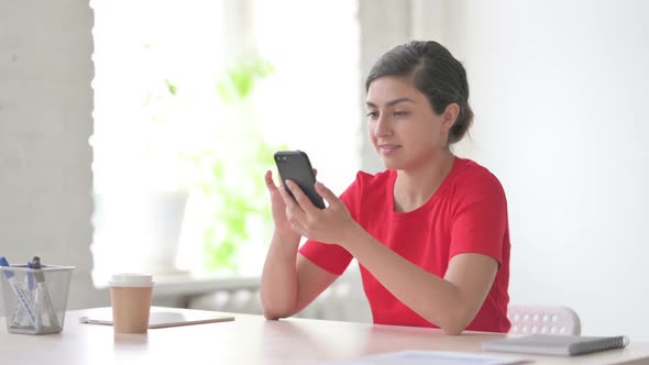 Indian Woman Celebrating Online Success on Smartphone