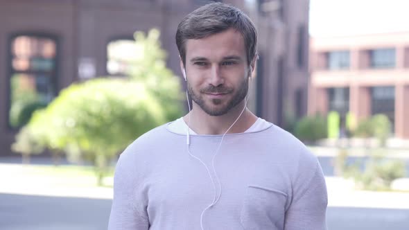 Happy Handsome Man Dancing and Listening Music in Open Air