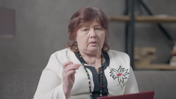 Portrait of Troubled Thoughtful Caucasian Senior Woman Sitting with Laptop at Home Thinking