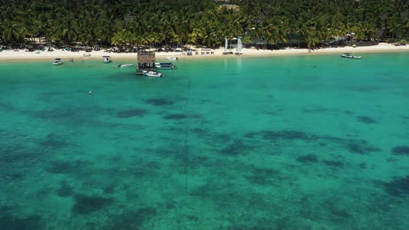 Tropical beach in Mauritius. Sandy beach with palms and blue transparent ocean. Aerial view
