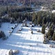 Aerial view of snow capped huts in the mountains, surrounded by spruce forest covered with snow - VideoHive Item for Sale