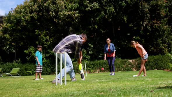 Happy family playing cricket