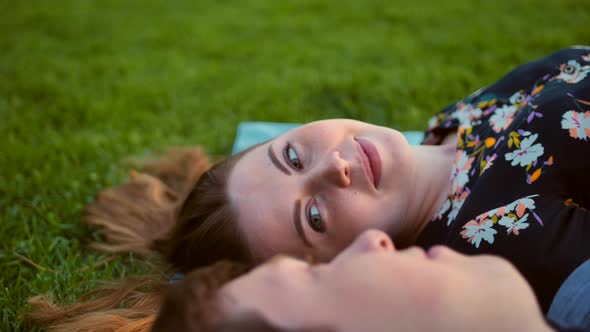 Happy Smiling Couple Relaxing on Green Grass. Female in Focus
