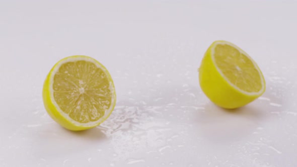 Lemon Divided Into Half on a White Background. Slow Motion.