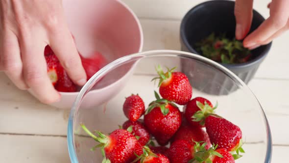Close Up Female Hands Peels Strawberries