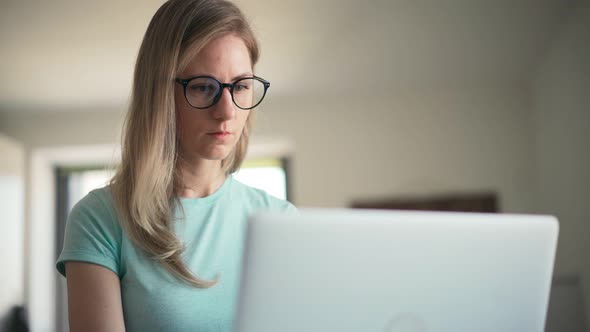 Young Adult Woman in Glasses Working on a Laptop From Home