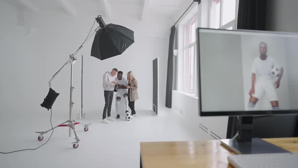 Monitor with an Advertising Cover of the Picture On the Background a Photographer a Football Player