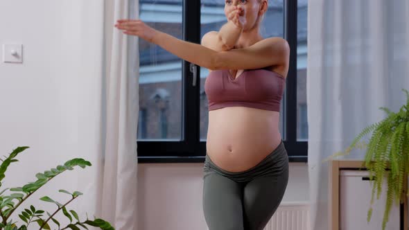 Happy Pregnant Woman Doing Yoga at Home