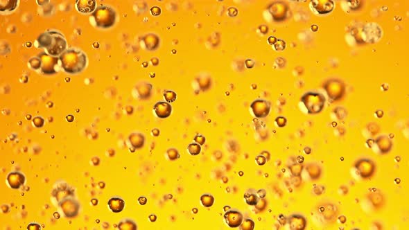 Super Slow Motion Shot of Moving Oil Bubbles on Golden Background at 1000Fps