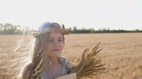 Serious Sad Girl a Child Stands on a Wheat Mown Field