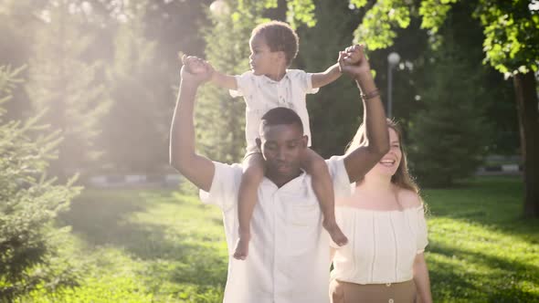 Happy Interracial Family is Walking in the Park