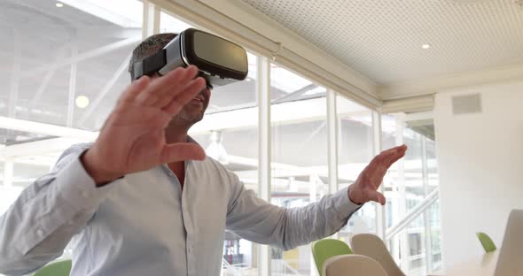 Businessman using virtual reality headset at desk in modern office 4 4k