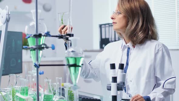 Biochemistry Researcher Looking at Plant Samples in Test Tubes