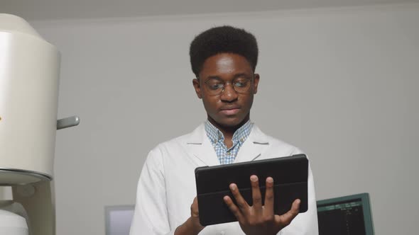 Close Up Portrait of Smiling Handsome African Doctor Holding Digital Tablet Pc