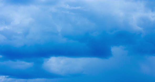 The motion of clouds on the background of the azure sky.