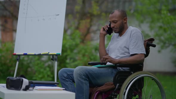 Side View of Confident Disabled Expert in Wheelchair Discussing Business Idea on the Phone Sitting