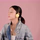 Happy pretty Asian teenager girl dancing and listening music by smartphone on pink background. - VideoHive Item for Sale