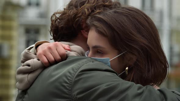 Lovely Couple in Medical Masks Hugging Outdoor