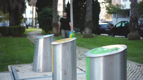 Bearded Male Walking to Waste Sorting Bins to Dispose of Garbage for Recycling