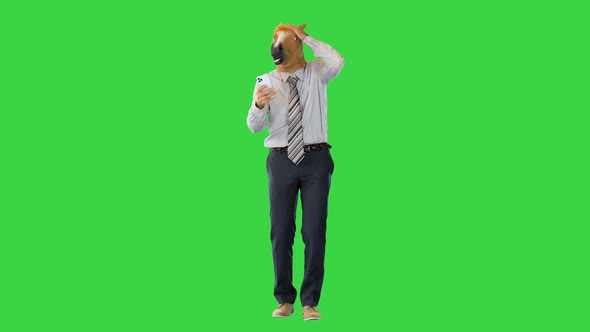 Businessman with Head of Horse is Shocked While Walking and Using Smartphone on a Green Screen