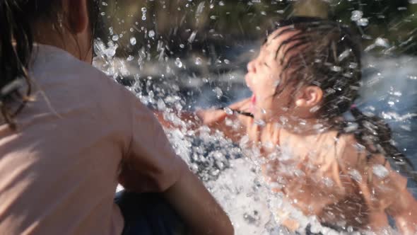 Asian little girl playing in the forest stream with her sister.