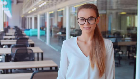 Businesswoman with Glasses at Workspace Shows Thumb Up