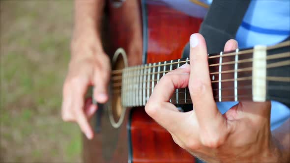 Closeup of the Creativ Hand's of a Manmusician Playing the Guitar Standing in the Street One Writes