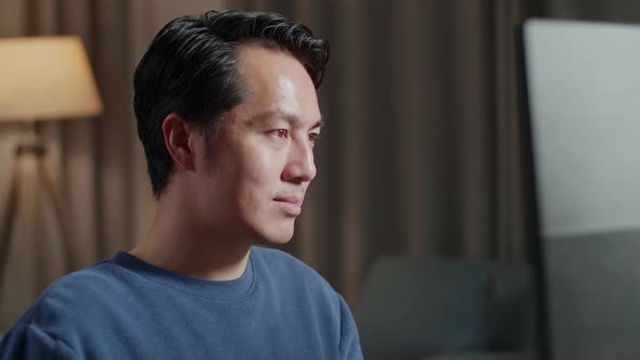 Smiling Asian Male Engineer With The House Model Working On A Desktop At Home