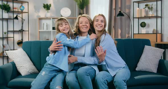 Mother and Her Two Daughters which Sitting on the Soft Couch in Beautifully Decorated